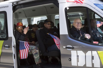 Vets wave the American Flag from the DAV, Disabled American Veterans, van during the 2016 annual America's Parade held on Veterans Day in Manhattan