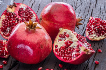 Ripe pomegranate fruit on wooden vintage background.