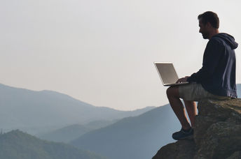 man working outdoors on laptop