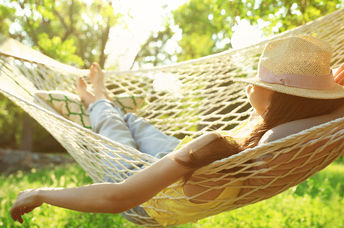 Happy woman relaxes in hammock