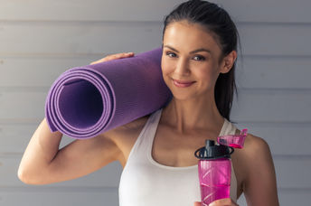 A woman getting ready to begin yoga poses on her yoga mat.