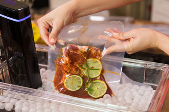 Marinated meat in a vacuum bag and a sous vide cooker.
