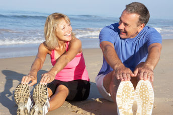 A couple stretching on the beach may have reduced hypertension.