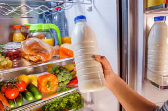 Woman checking on expiration date on milk.