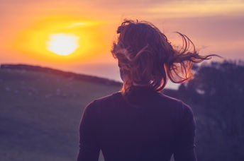 Woman on a mindfulness-inspired awe walk admiring the sunset