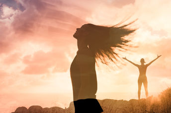 Woman triumphant at sunset
