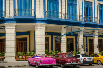 Classic cars are among the taxis waiting for passengers outside of Cuba’s Hotel Telégrafo