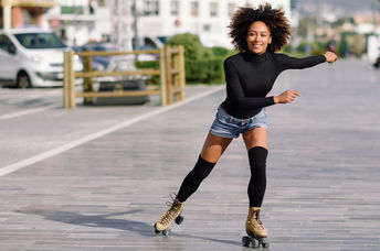 Young woman on roller skates riding outdoors in urban street