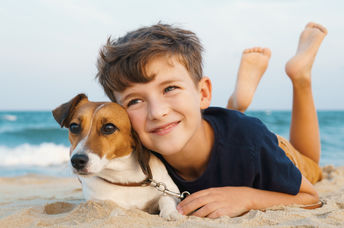 Happy boy hugging his Jack Russell terrier at the seashore