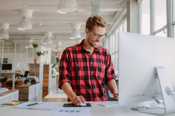 Happy young man working at a standing desk