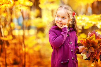 Happy little girl in autumn maple orange leaves