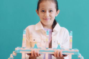 Girl proudly showcasing her LEGO creation