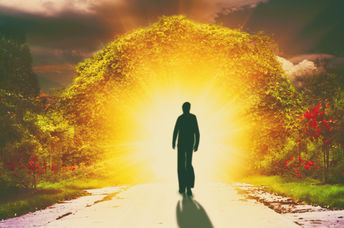 A person walks down a road into light, reflecting the spiritual love a lightworker shines.