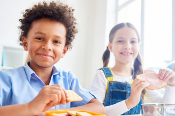 School kids eating snacks from containers at break