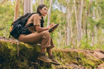 A biologist researches and records information discovered in the forest.