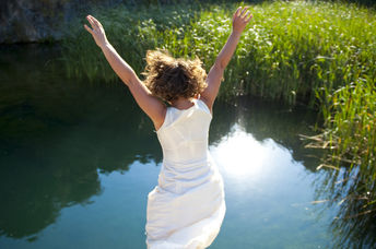 Young woman jumping into an idyllic lake.