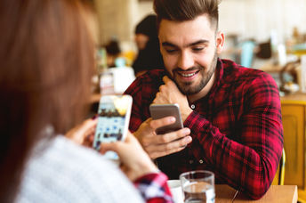 Couple using their mobile phones in a cafe.