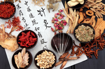 Traditional Chinese medicine herbs, and acupuncture needles.