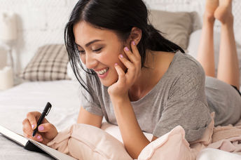 Young woman relaxing with a notebook and pen in her hands.
