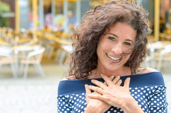 Grateful woman with her hands to her heart.