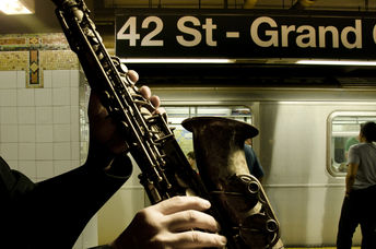 A man playing the saxophone at a subway station.