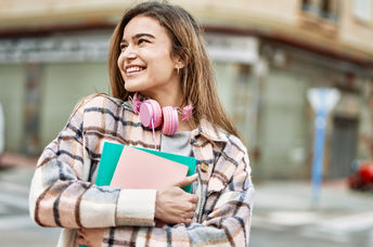 A young woman holding books.