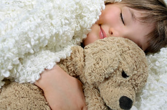 Smiling girl holding a precious soft toy.