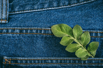 A pair of sustainable jeans with green leaves in the back pocket.
