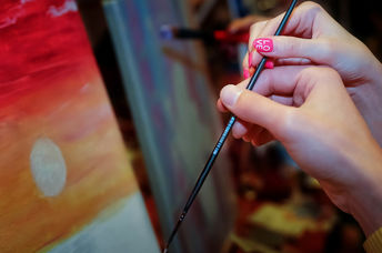 A couple holding a paint brush.