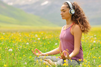 woman listening to guided meditation in nature