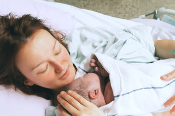 Mother cuddling her newborn baby.