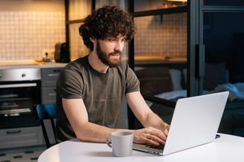 A young man typing on a laptop.