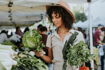 Woman buying kale at a farmers’ market