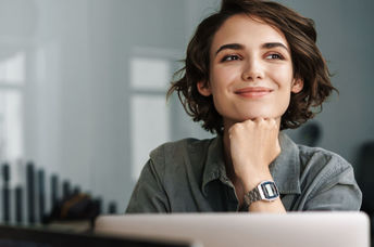 A smiling woman working on her laptop.