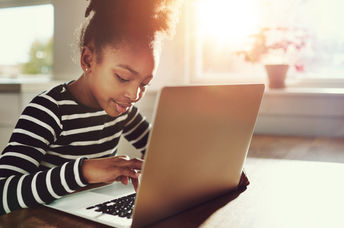 A young girl using a laptop.