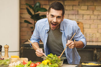 An enthusiastic chef cooks in the kitchen.