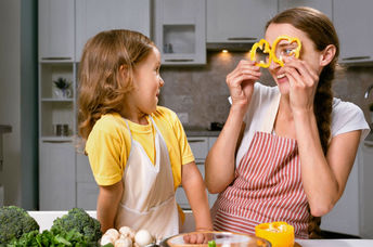 A mother and daughter have fun preparing vegetables, an important food in a psychobiotic diet.