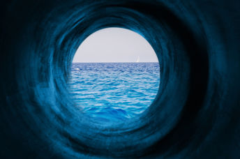 Blue tunnel to a calm sea symbolizing the way to tranquility and goals.