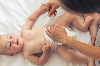 Mother diapering her baby.