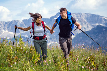 Hikers in a mountain meadow are exploring the world in a sustainable way.
