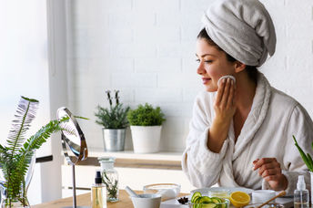 Woman giving herself a facial with DIY beauty products.