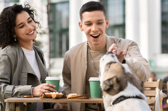 Couple enjoying eating out with their dog.