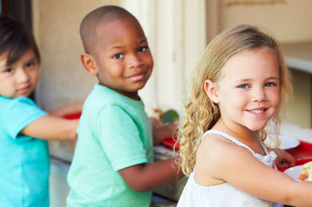 Elementary pupils collect healthy school lunches in the cafeteria.