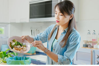 Korean woman saving food scraps.