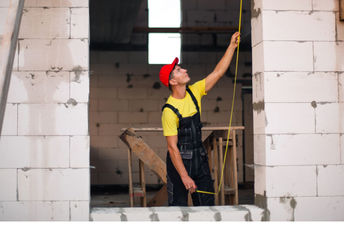 Construction worker using concrete blocks.