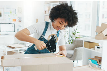 Woman using tape to seal a box.