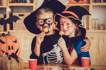 Costumed children enjoying festive foods.