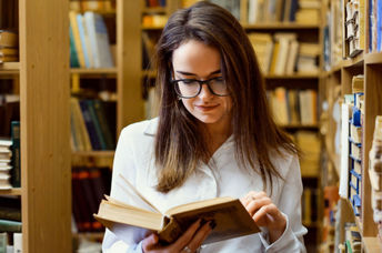 A woman looking words up in a dictionary.