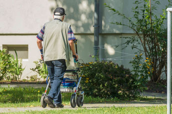 Senior man walking in his yard.