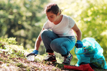 Teenage girl cleaning a community park.